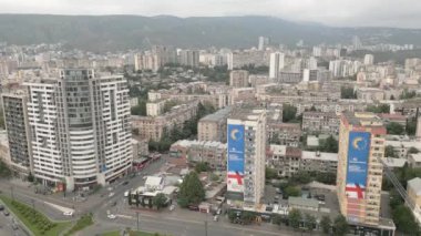 Gürcistan 'ın başkenti Tiflis' te arabaları olan modern emlak bloğu binaları çatıları ve caddelerin üzerinde uçan hava aracı. Kentleşme ve emlak geliştirme kavramı