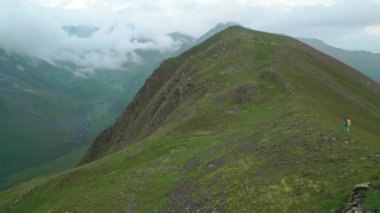 Hava manzaralı tek başına beyaz kadın yürüyüşçü Kafkasya dağlarında yavaş yavaş yokuş yukarı tırmanıyor. Sakori göl yürüyüş yolu. Kadın meydan okuması zirveye ulaşıyor