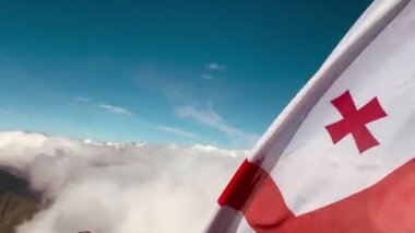 Gürcistan bayrağını Kafkasya dağları ve Kazbek tepe arkaplanı ile kapatın. Seyahat gezisi Gürcistan bayrağını ziyaret et