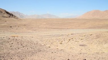 Terkedilmiş dağların manzarasını ve güneşli bir günde uzak çakıl yollarının manzarasını izlemek.