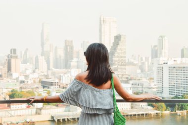 Bangkok, Tayland - 11 Şubat 2024: Kafkas kadın turist alışveriş merkezinin keyfini çıkarın güneşli ve sıcak bir günde nehrin üzerinde Tayland 'ın Bangkok şehrinde ünlü bir bakış açısına bakın.
