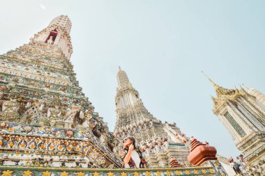 Genç kadın gezgin blog yazarı güzel Budist tapınağı Wat Arun 'dan poz verdi. Tayland' ın Bangkok şehrinde ünlü bir seyahat merkezi. Güneydoğu Asya 'da tarihi yerleri gezen turistler