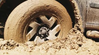 4WD ön tekerlek çamura saplanmış, kapalı alanda iki adam tarafından itilmiş. Şiddetli yol koşulları yağmur konseptinden sonra yaz
