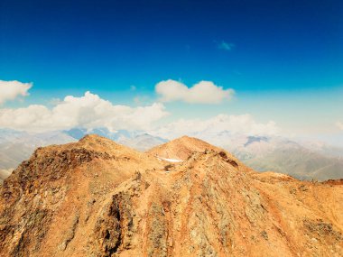 Alp bölgesindeki renkli vadilerle hava manzaralı Kafkas dağları. Arka planda Kazbek dağı zirvesi