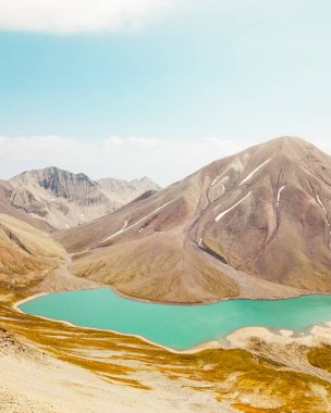 Havadan panoramik görüntü Kelitsadi Gölü Panoraması. Keli volkanik yaylası. Kazbegi Ulusal Parkı. Kafkas dağları. Georgia 'nın ünlü yürüyüş merkezi. Güneşli yaz günü dağları, Kafkasya' nın el değmemiş dağları.