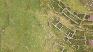 Tepenin yamacındaki terk edilmiş Arsha köyü havadan görünüyor. Kazbegi Ulusal Parkı. Gürcistan Kafkasya dağlarında gizli mücevher manzarası