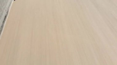 Eğik görüş, araba ön tekerlek POV bakış açısı, kırsal alanda dönen yakın çekiş, güneşli bir günde, sonbahar ormanlarında boş asfalt yolda. Kış araba lastiği değişti.
