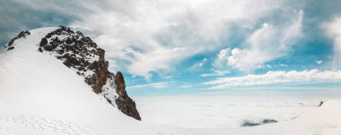 Gürcistan 'daki ünlü Kazbek Dağı zirvesine ulaşan iki bulutun üstündeki hava manzaralı dağcı grubu. Kazbek Dağı ya da Kazbegi Dağı, Kafkasya 'nın en büyük dağları olan stratovolcano' nun hareketsiz halidir.