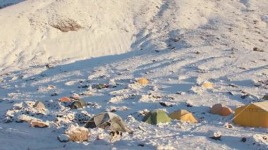 Renkli çadırları ve karda başıboş köpekleri olan Bethlemi barakası manzarası. İklime alışma konsepti. Kazbek Dağı 'na tırmanıyorum. Kazbegi belediyesi. Güneşli bir günde Karlı Kafkasya Dağı manzarası