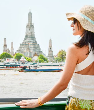 Güzel, zarif, beyaz kadın blogcu turist portresi Wat Arun tapınağına bakıyor. Güneydoğu Asya tek başına tatil turizmi konsepti