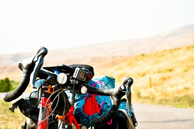 Background image of standing touring bicycle without cyclist on the road with nocars. Cycling in a countryside. Kazkbegi national park. Georgia.2020 clipart