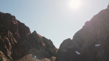 Hava sineği, engebeli dağ tepelerinde, gün batımında soluk kesici dağ sıralarında yakalanan kar parçalarıyla kıvrılarak uçuyor. Kafkas Egrisi menzili. Georgia dağları