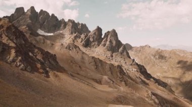 Hava sineği, engebeli dağ tepelerinde, gün batımında soluk kesici dağ sıralarında yakalanan kar parçalarıyla kıvrılarak uçuyor. Kafkas Egrisi menzili. Georgia dağları