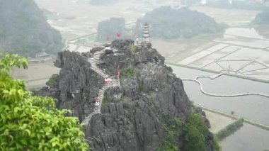 Ninh Binh, Vietnam 'da popüler Hang Mua pagoda' yı gezen turist manzarası. Arka planda kireçtaşı kayalıkları olan Pagoda ile Mua Bakış Asın