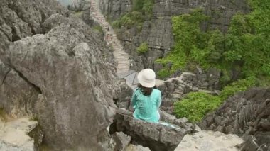 Beyaz kadın turist, Ninh Binh, Vietnam 'daki manzaralı manzara ziyaretlerinden keyif alıyor.