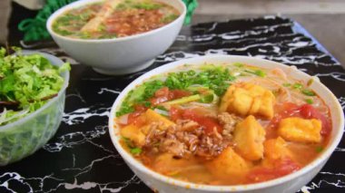 Pho - Vietnam çorbası çorbası çorbası çorbası çorbası, pirinç eriştesi, şifalı otlar ve yerel bir restorandaki masada et. Pho - Sokaklarda ve evlerde servis edilen Vietnam 'da popüler yiyecekler