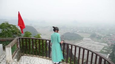 Beyaz kadın turist, Ninh Binh, Vietnam 'daki manzaralı manzara ziyaretlerinden keyif alıyor.