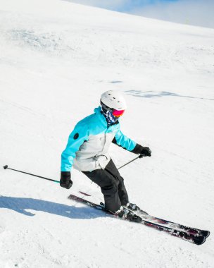 Kış karlı dağların yamaçlarında uzman kayakçı açık havada güneşli bir gün ve kar spreyi. Yetenekli ve profesyonel kayak hocası.