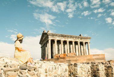 Turist mutlu genç bayan gezgin, UNESCO 'da listelenen antik bir Yunan mimari ve din abidesi olan Ermenistan' daki ünlü Garni Tapınağı 'nı gezmeye bayılıyor. Klasik sütunlu yapı