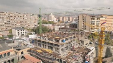 Vinç taşıma bloğu malzemesi ve şantiyede çalışan işçilerin bulunduğu hava görüntüleme şantiyesi. Kantron bölgesinde emlak işi. Erivan sermaye yatırımları kavramı