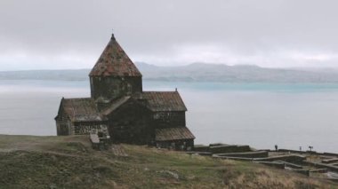 Ermeni ziyaretçi Sevanavank manastır kompleksi ve Ermenistan 'ın Gegharkunik ilinde Sevan Gölü panoraması. Ermeni kültüründe din kavramı. Arama amacı insan kavramına cevap verir.