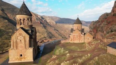 Noravank manastır kompleksini geçen hava manzarası, 13. yüzyıl Ermeni manastırı. Kutsal Meryem Ana Kilisesi. Amaghu 'daki Noravank. Kızıl kayalıklar Arani köyünü dolduruyor. Ermenistan 'da turizm beldesi