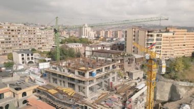 Vinç taşıma bloğu malzemesi ve inşaat alanında çalışan işçilerle hava statik manzaralı inşaat alanı. Kantron bölgesinde emlak işi. Erivan sermaye yatırımları kavramı