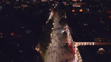 Havadan aşağıya bakan insanlar sokaklarda yürür ve bayraklarla birlikte yürür. Vatandaşlar hükümet karşıtı protestolara katılarak özgür iradelerini ve demokratik haklarını ifade ediyorlar.