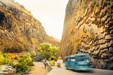 Motion people visit sightseeing popular travel destination in armenia - Basalt columns in Garni Gorge, know as Symphony of Stones. Geological formation of octagonal basalt columns. Motion blur clipart