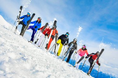 Gudauri, Gürcistan - 25 Ocak 2022: Güneşli bir günde güneşli dağlarda teçhizatlarla birlikte poz veren sekiz mutlu kayakçı grubu
