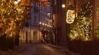 Vilnius, Litvanya - 30 Kasım 2024: İnsan Stikliai Caddesi 'nde ünlü Vilnius eski kasaba bölgesinde tatil süslemeleriyle yürüyor