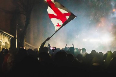 Tiflis, Gürcistan - 1 Aralık 2024: Gürcü gençliği parlamentonun önünde Gürcistan bayraklarını sallıyor. Rustaveli Caddesi 'ndeki miting soğuk gecelerde. Özgürlük ve Avrupa Birliği için mücadele.