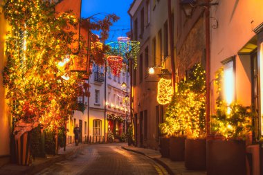 Vilnius, Litvanya - 30 Kasım 2024 Vilnius eski kasabasındaki ünlü Stikliai caddesinde muhteşem yaratıcı Noel süslemeleri. Tatil süslemeleri. Kafeler ve restoranlardan parlak ışıklar dekorasyonu