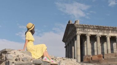 Turist mutlu genç bayan gezgin, UNESCO 'da listelenen antik bir Yunan mimari ve din abidesi olan Ermenistan' daki ünlü Garni Tapınağı 'nı gezmeye bayılıyor. Klasik sütunlu yapı