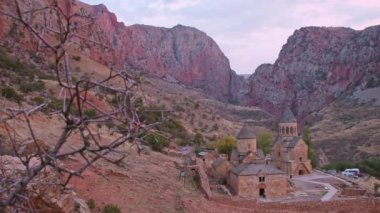 Gün batımı dramatik manzarası Noravank manastır kompleksi, 13. yüzyıl Ermeni manastırı. Kutsal Meryem Ana Kilisesi. Amaghu 'daki Noravank. Kızıl kayalıklar Arani köyünü dolduruyor. Ermenistan 'da turizm beldesi