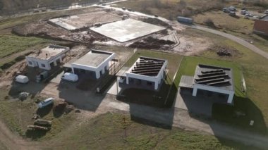 Siauliai, Litvanya, 2024: çatıdaki havadan aşağı görüşlü işçiler özel mülkiyet için güneş panelleri kurulumuna hazırlanıyorlar. Şehrin banliyölerinde yeni yeşil ev gayrimenkulleri