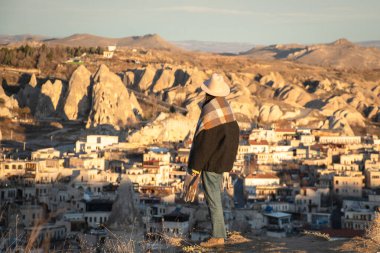 Kadın turist, ünlü Goreme köyünde gün batımının tadını çıkarıyor. Kapadokya Türkiye 'ye seyahat ediyor. Mağara evi otelleri ve Anadolu 'da kalıyor.