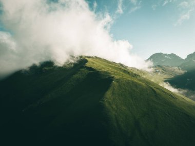 Tepenin tepesinde yeşil aucasus dağları manzaralı tek bir çadır. Dağın tepesinde yeşil kamp çadırı ve arka planda muhteşem bir gündoğumu. Temiz hava için zaman harcamak. Seyahat kavramı