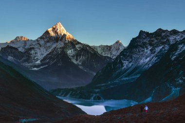 Ama dablam dağ zirvesi ve Cholatse gölü. Sagarmatha Ulusal Parkı. Ama Dablam - Nepal 'in Koshi eyaletinin doğu Himalaya bölgesinde bir dağ. Ana tepe. Erkek ve kadın yürüyüşçü.
