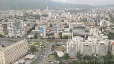 Gürcistan 'ın başkenti Tiflis' te arabaları olan modern emlak bloğu binaları çatıları ve caddelerin üzerinde uçan hava aracı. Kentleşme ve emlak geliştirme kavramı
