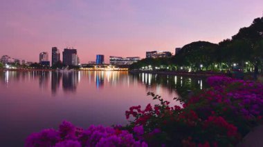 Benjakitti Parkı 'nda günbatımının 4k zamanı. Bangkok, Tayland 'ın Khlong Toei semtinde halka açık bir park. Benjakitti parkında gün batımı