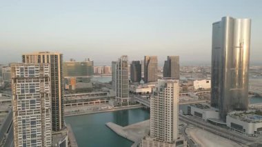 Abu Dabi, BAE - 25 Nisan 2025: Hava güneşli panorama Abu Dabi şehir merkezi gündoğumunda modern apartman binaları ve Cleveland Kliniği Abu Dabi kompleksi