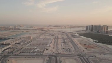 Abu Dabi 'deki sanayi bölgesinin geniş bir görüntüsü var. Üretim altyapısı, ağır makineler ve BAE endüstriyel sektöründe ekonomik kalkınma. Arka planda Zayed Limanı ve Louvre Müzesi