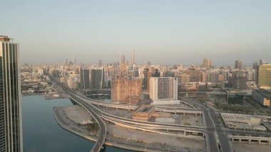 Abu Dabi, BAE 25 Nisan 2025: Sabah erken saatlerde Abu Dabi banliyösü boş otoyolları ve gündoğumuyla aydınlanan konut binaları ile sakin şehir genişlemesini ve ulaşım altyapısını gösteriyor
