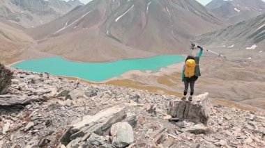 Gökyüzü manzaralı genç kadın Hiker ayakta dururken ve Gürcistan 'daki güzel dağları izlerken kollarını kaldırıyor. Kazbegi, Kelitsadi Gölü, Georgia