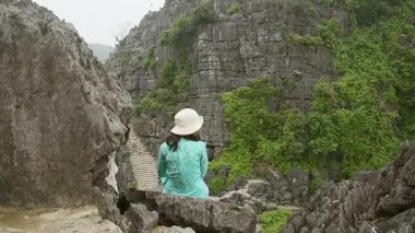 Beyaz kadın turist, Ninh Binh, Vietnam 'daki manzaralı manzara ziyaretlerinden keyif alıyor.