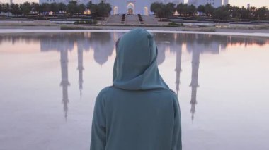 Blog yazarı ziyaretçi Abu Dabi 'deki güzel Şeyh Zayed Büyük Camii' nin geleneksel Arap elbisesini giyiyor. Büyüleyici caminin çarpıcı simetrik yansımaları.