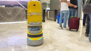 Robot Abu Dabi Havaalanı Akıllı Seyahat Deneyimi 'nde Su Hizmeti Veriyor. Lüks salonda misafir. Yapay zeka ve otomasyon yoluyla günlük hayatta hizmet veren kavramsal teknoloji