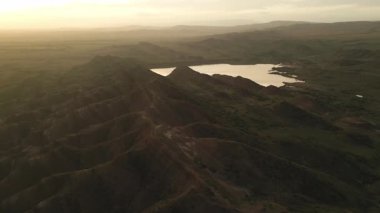Gökkuşağı ya da kızıl dağların üzerinden uçan gökkuşağı dağlarının renkli katmanları Gürcistan, Kafkasya bölgesinde. Çarpıcı mineral desenleri, yuvarlanan tepeler yukarıdan gerçeküstü, resmedilmiş bir manzara oluşturur.