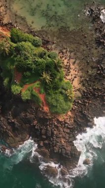 Havadan aşağı Mirissa Sahili ve Papağan Kayası, el değmemiş turkuaz suları, altın kumlu kıyılar, kayalık kıyı oluşumları, güney Sri Lanka. Canlı tropik Hint okyanusu manzarası